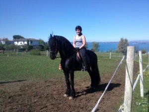 Verletur - eine lachende Frau auf einem Friesen am Gardasee